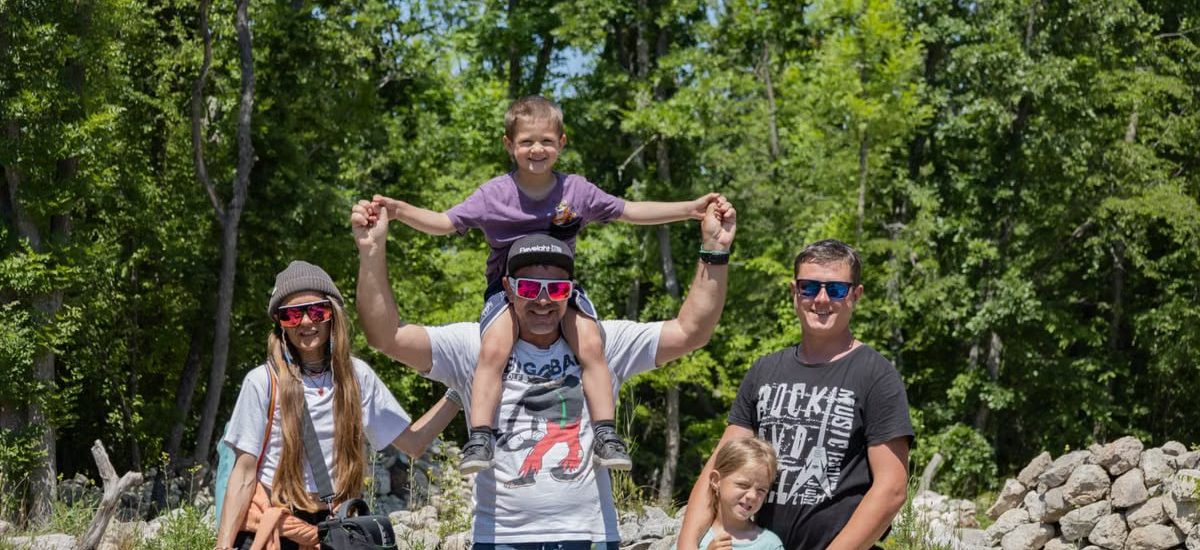 A joyful family enjoying a sunny day outdoors, captured in a lively and happy moment.